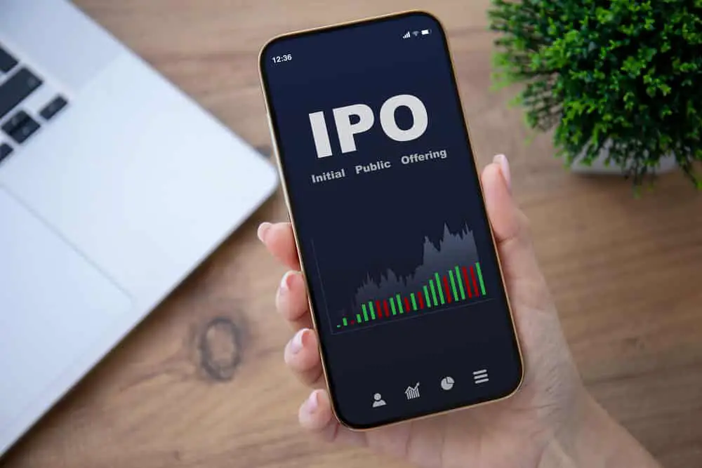 Female hands hold a phone with IPO stocks purchase app. 