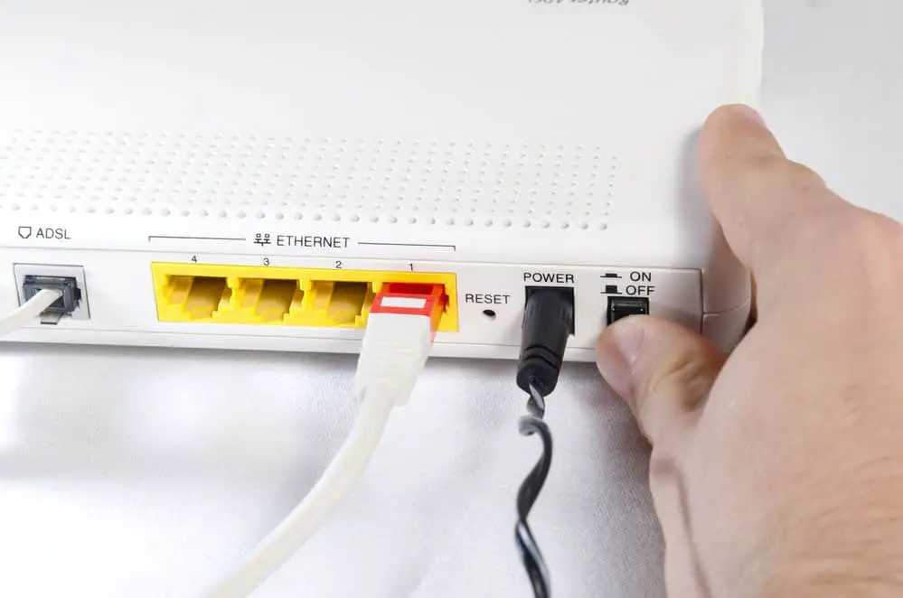 Hand in foreground connected to an internet router