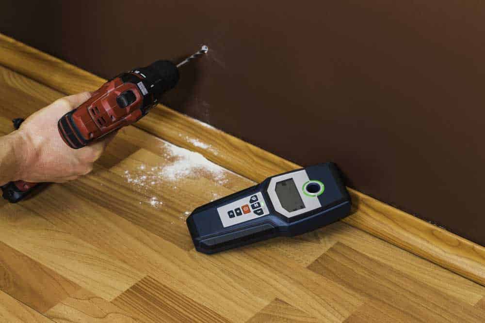 Drilling holes in the wall.
