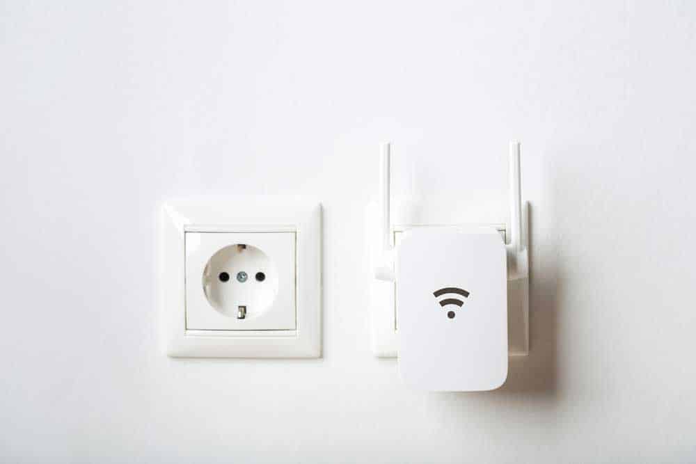 A white WiFi repeater on the wall. 