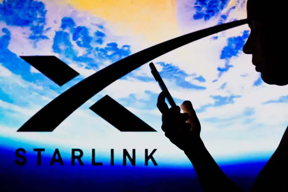 A woman in the background overlaid on a Starlink logo 