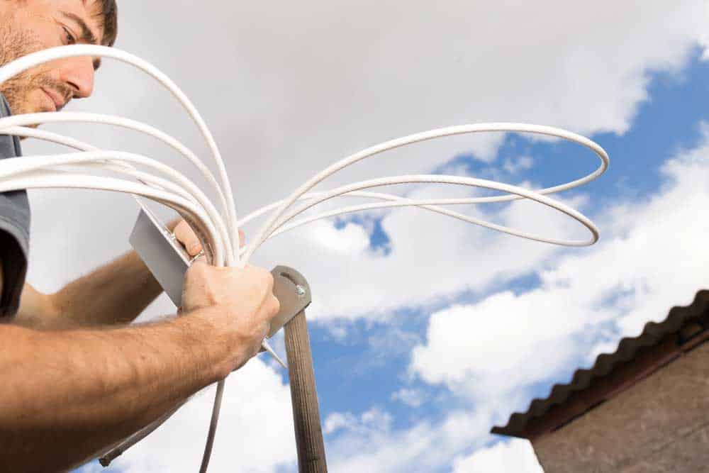 A technician is installing a dish.