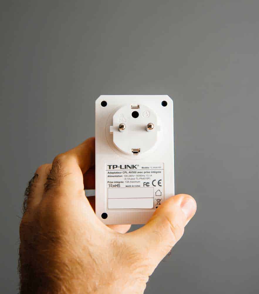 A white WiFi repeater on the wall.