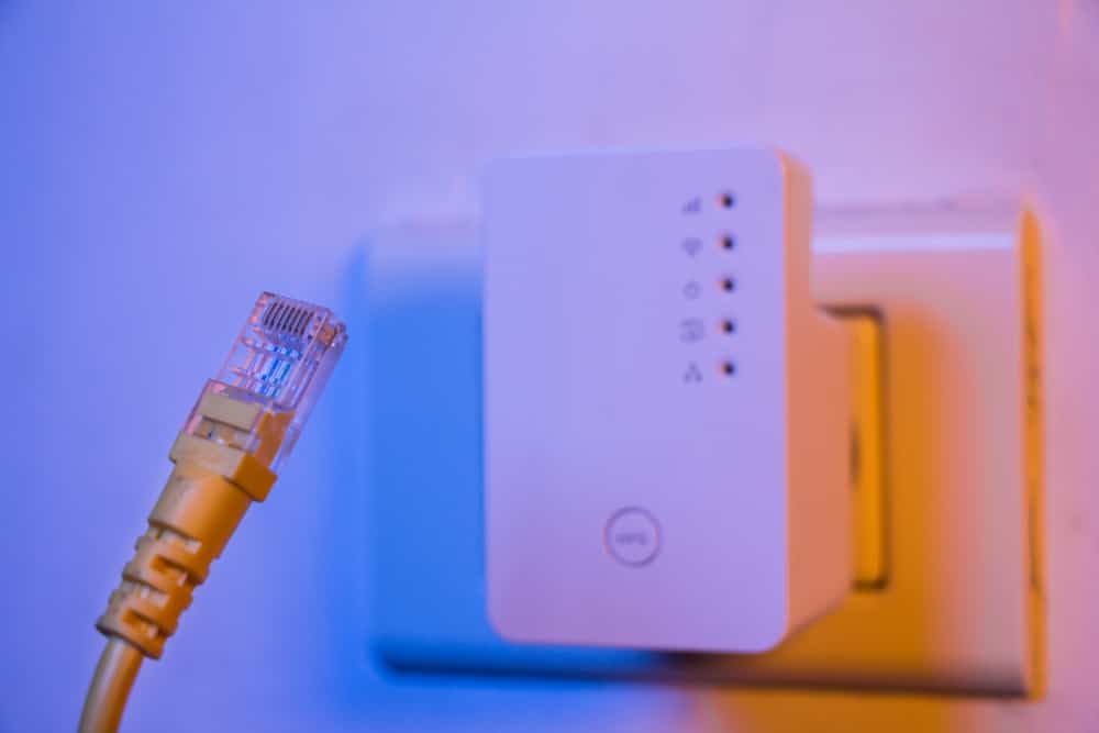An ethernet cable next to an extender.