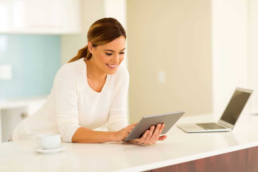 A happy woman is browsing the internet.