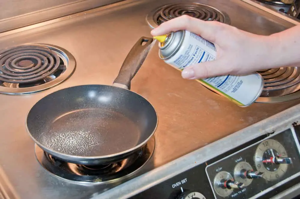 A cook spreads cooking spray.