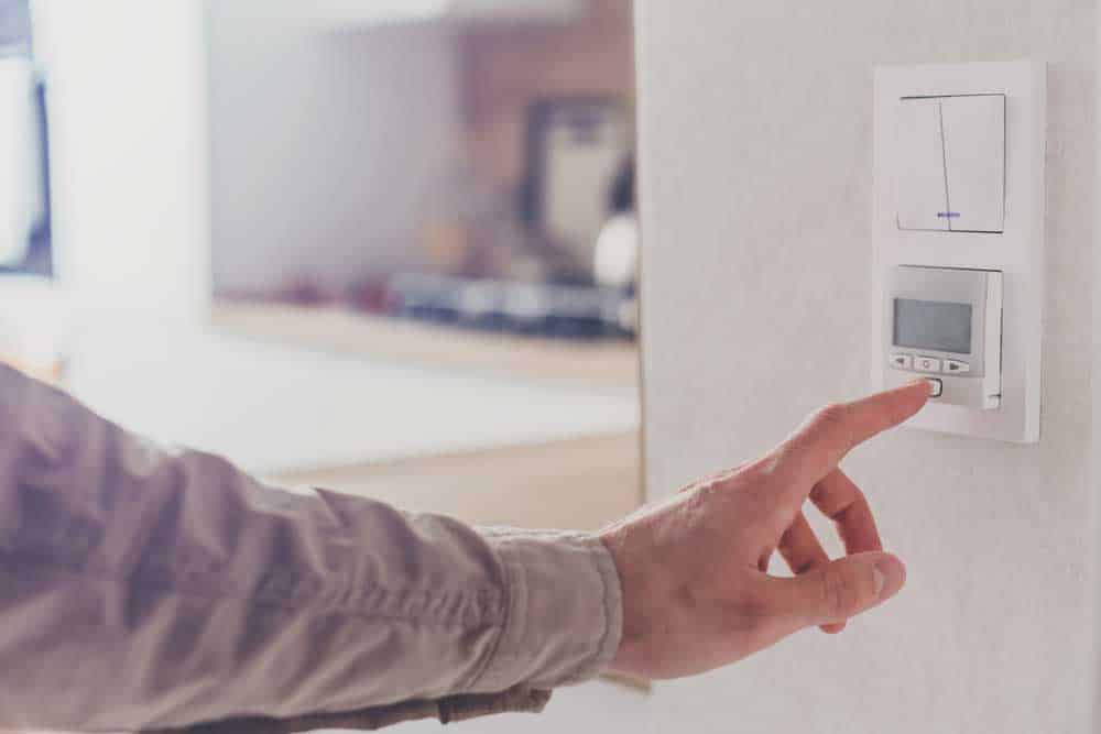 Man resetting thermostat in the home 