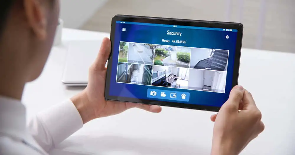 Businessman using home security camera on tablet PC