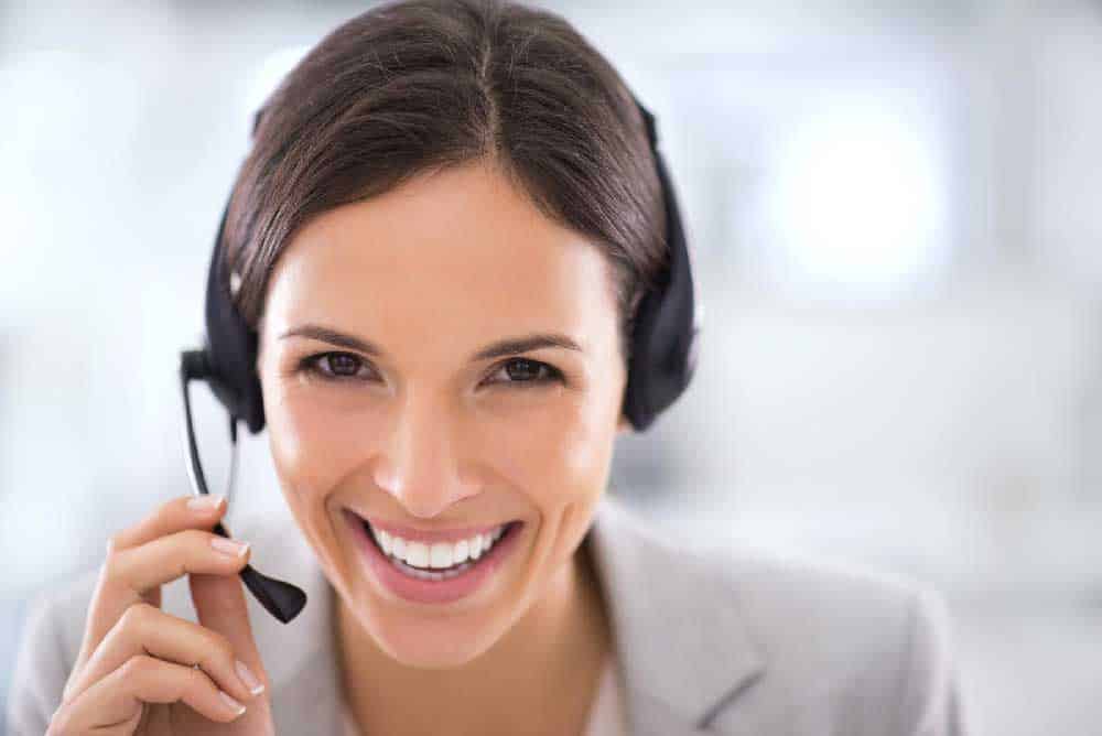 A female customer support agent smiling